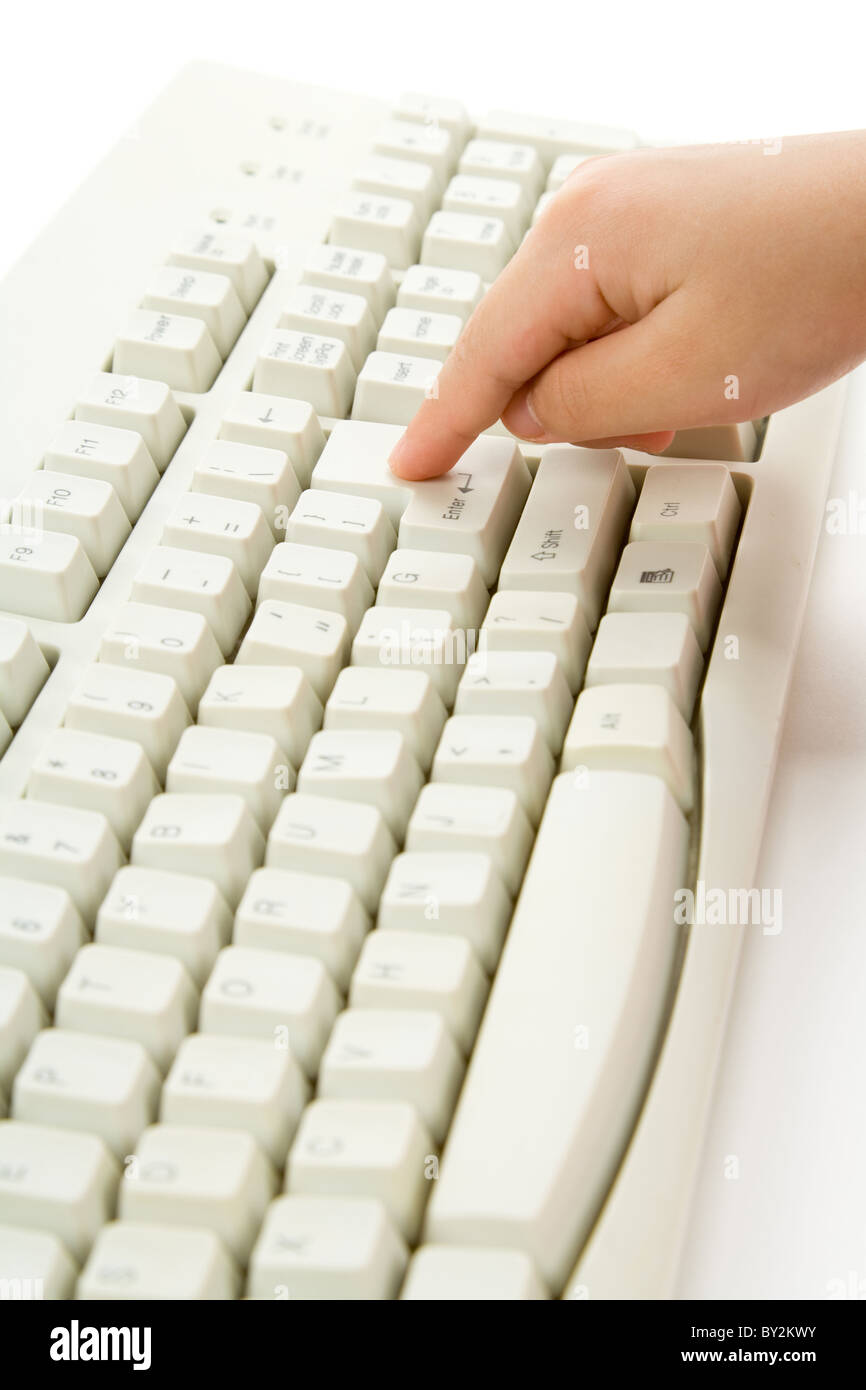 La main de l'enfant et l'aide du clavier de votre ordinateur. Banque D'Images