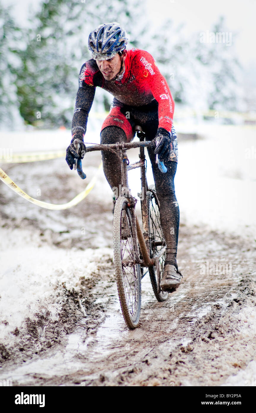 Les courses cyclistes un dans la boue et la neige lors d'une course de cyclocross à Boulder, CO. Banque D'Images