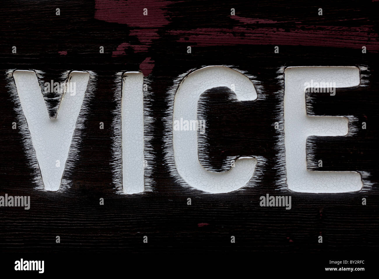 Close up d'un panneau en bois peint qui a le mot "vice" dessus. La peinture est de et de propagation. Banque D'Images
