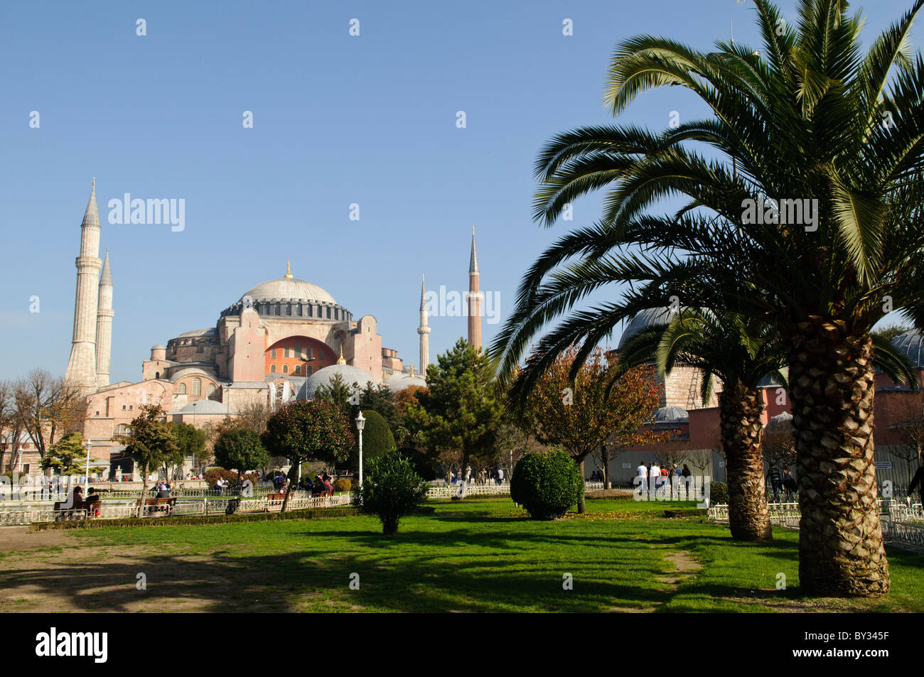 Hagia Sophia dômes et minarets Istanbul Turquie // ISTANBUL, Turquie — la basilique Sainte-Sophie vue depuis le parc du Sultan Ahmet, montrant ses dômes, minarets et contreforts distinctifs contre la ligne d'horizon d'Istanbul. L'extérieur du bâtiment reflète à la fois ses origines byzantines et ses ajouts ottomans, avec le dôme central flanqué de quatre minarets ajoutés après sa conversion en mosquée en 1453. Banque D'Images