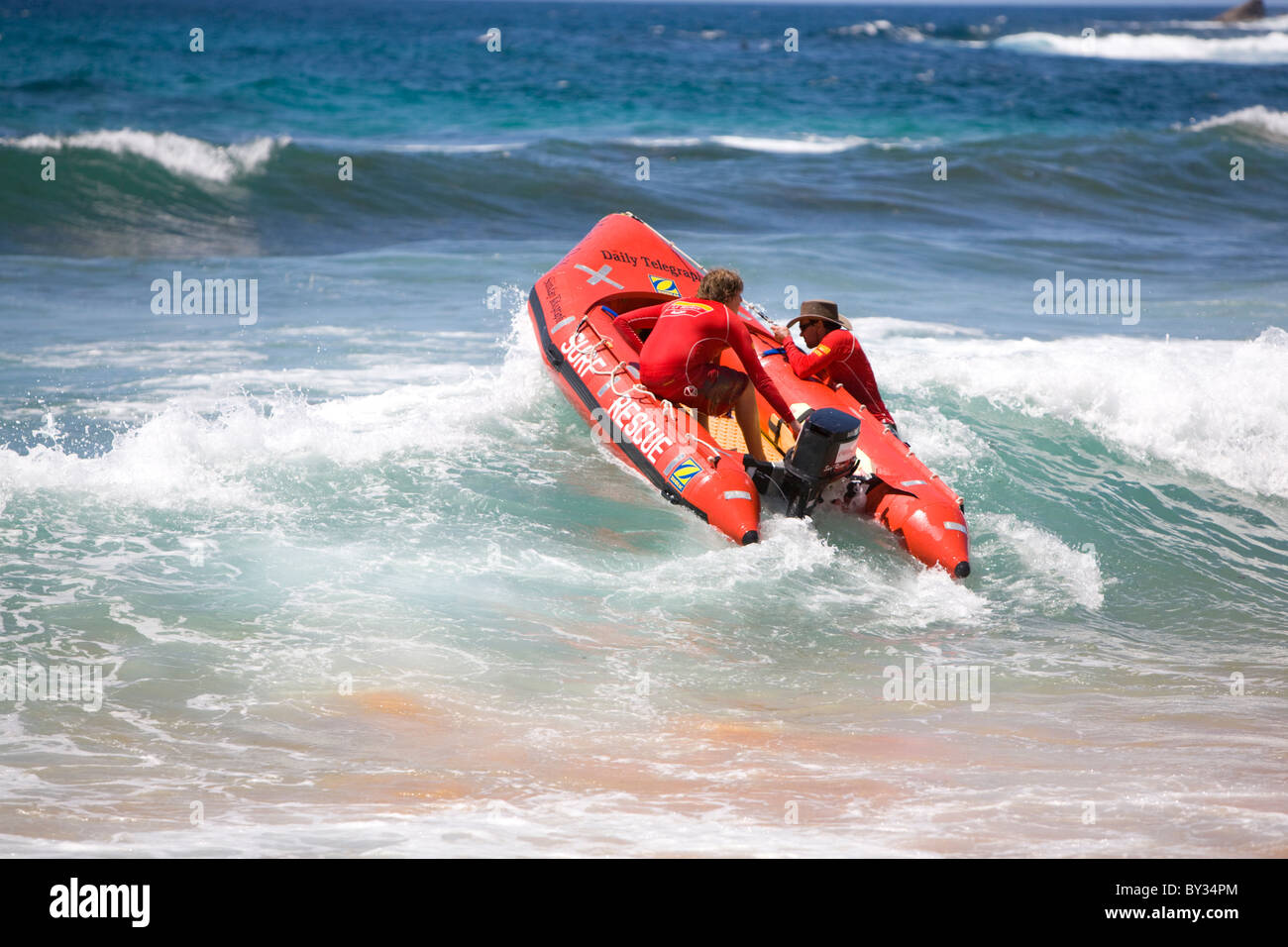 Deux sauveteurs de surf emportant leur bateau de sauvetage de surf IRB dans le surf, Avalon Beach, Sydney, Nouvelle-Galles du Sud Australie Banque D'Images