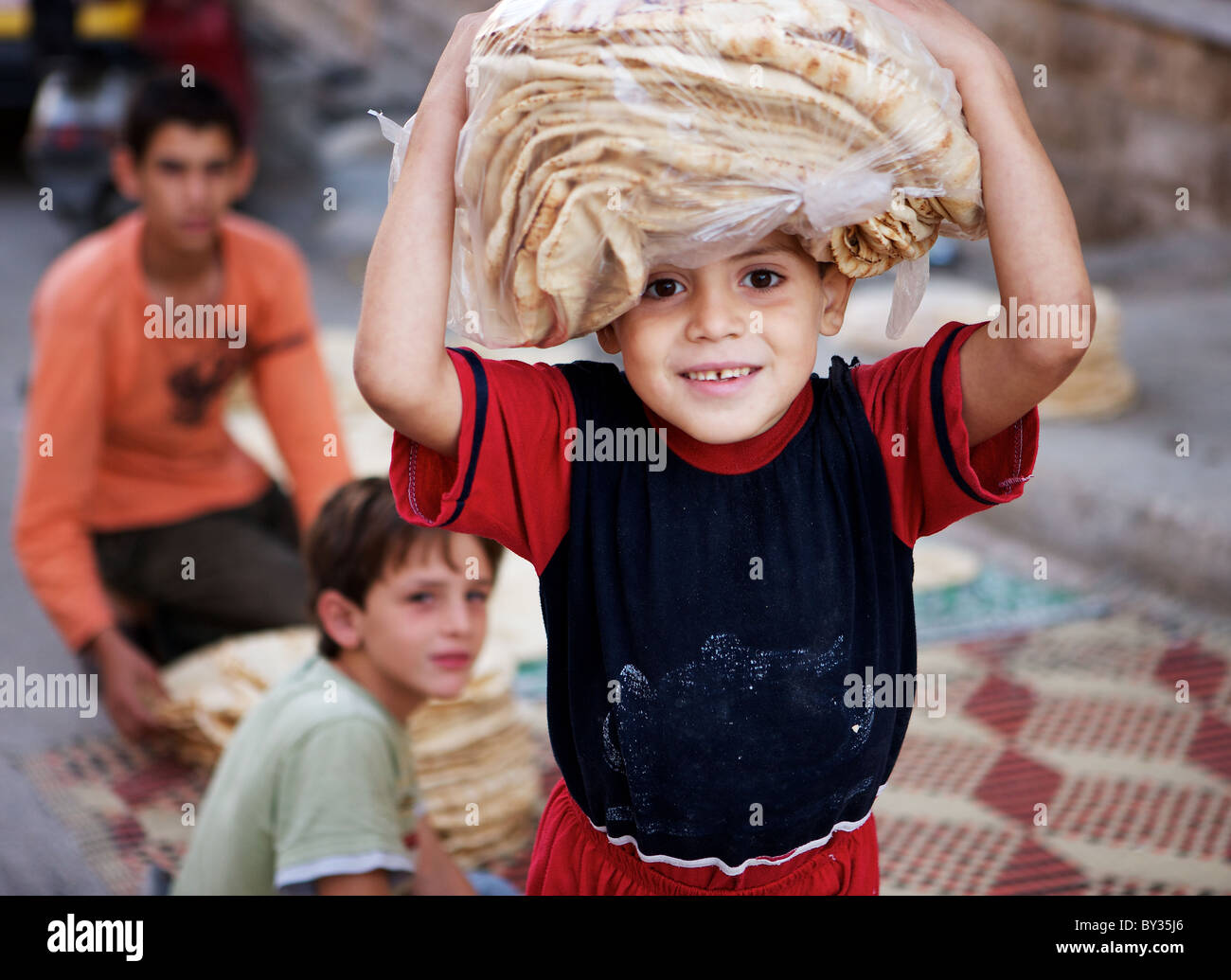 République boy carrying pain frais sur sa tête à Hama, en Syrie Banque D'Images