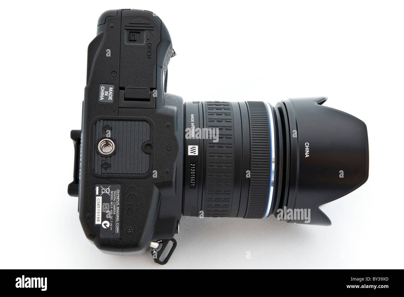 Studio nature morte. Dessous vue d'un appareil photo reflex numérique Olympus fabriqués en Chine avec des étiquettes sur un fond blanc Banque D'Images
