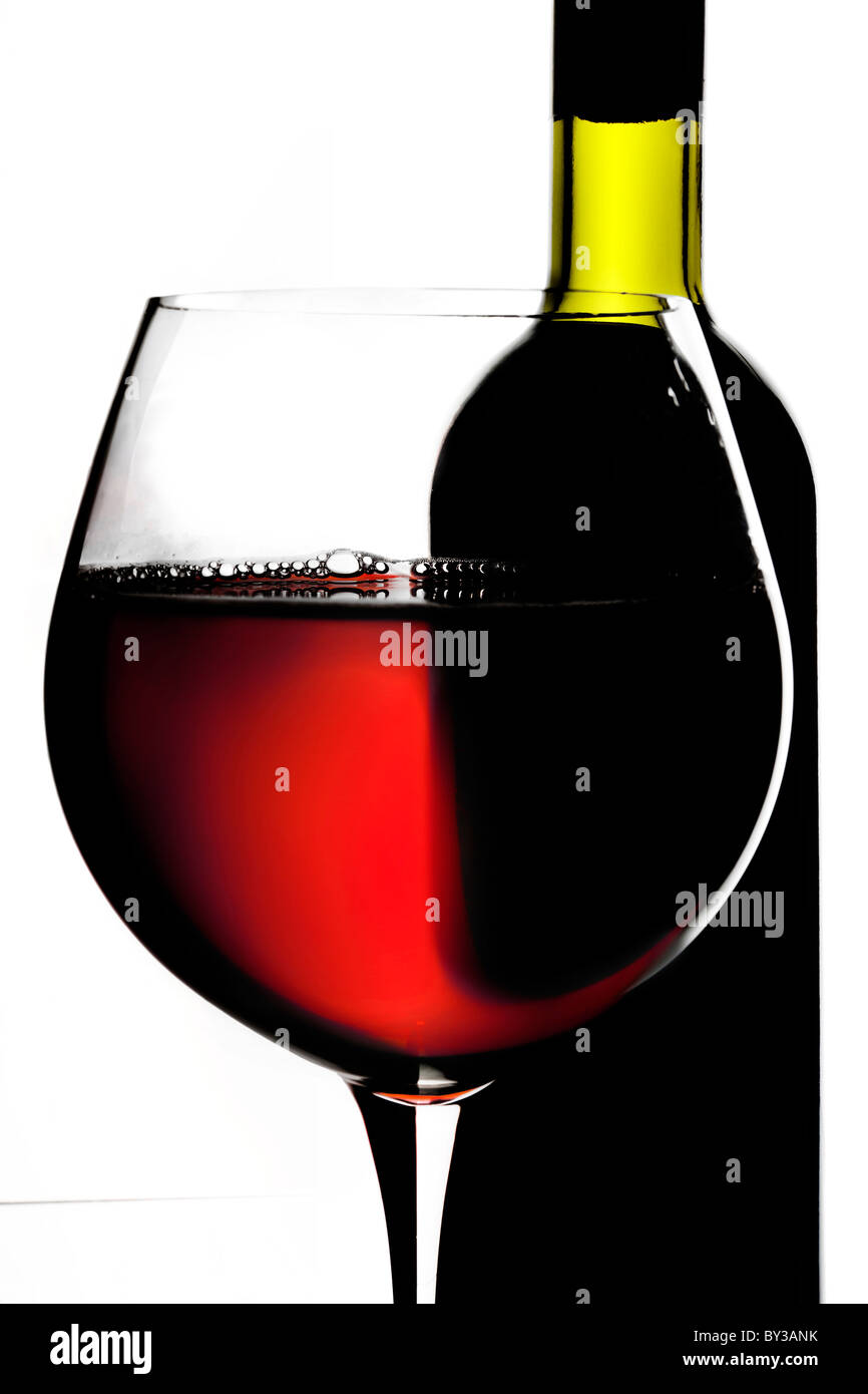 La nature morte avec bouteille et verre de vin rouge sur fond blanc. Banque D'Images