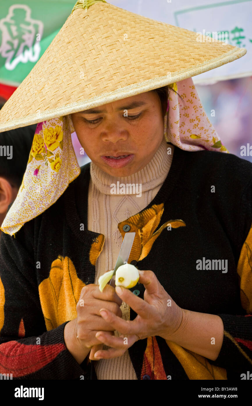 Woman peeling apple en Menghai Marché de Fruits, Province du Yunnan, Région Xishuangbanna, République populaire de Chine. JMH4194 Banque D'Images