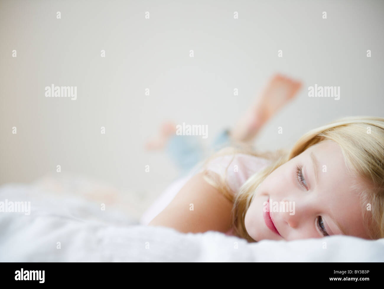 USA, New Jersey, Jersey City, Girl (8-9) laying in bed Banque D'Images