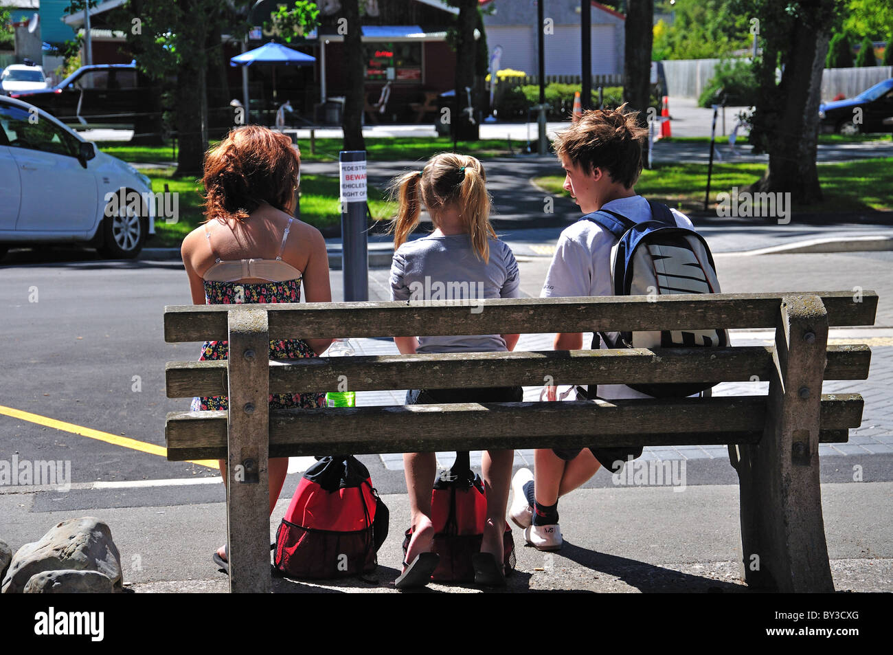 Les enfants assis sur un banc, Hanmer Springs Thermal Pools & Spa, Hanmer Springs, Canterbury, île du Sud, Nouvelle-Zélande Banque D'Images