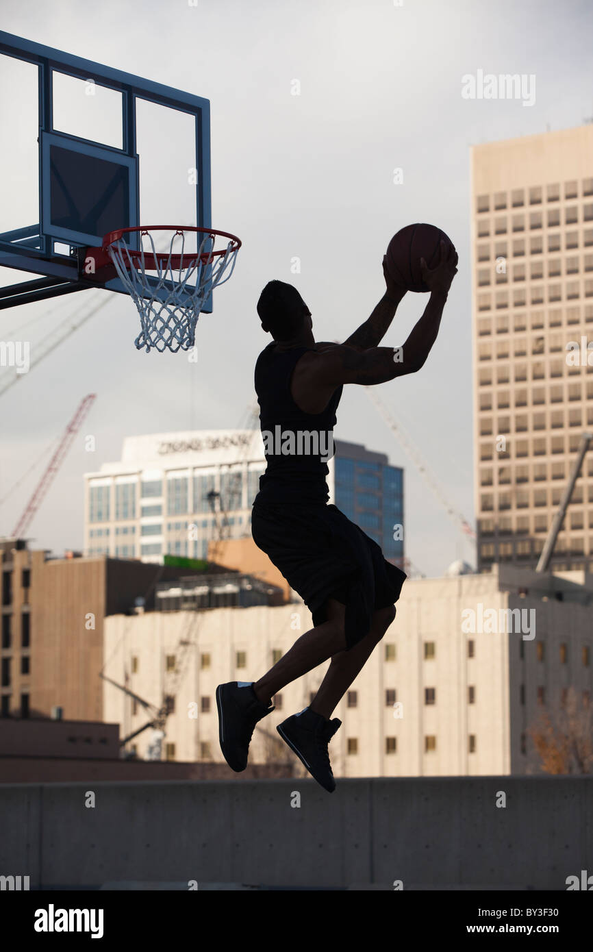 USA, Utah, Salt Lake City, Silhouette de jeune homme jouant au basket-ball Banque D'Images