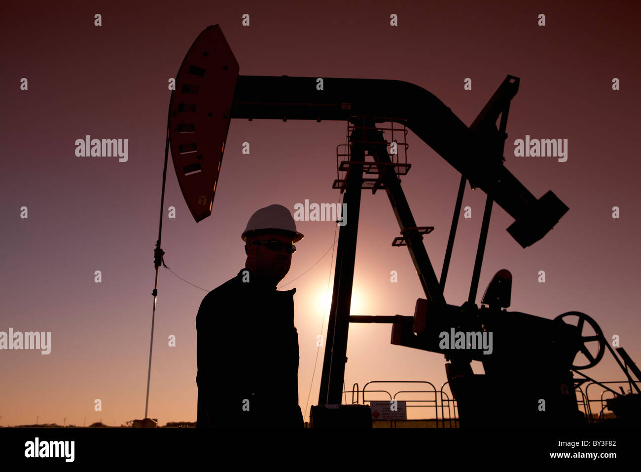 Silhouette de travailleur d'huile par la pompe sur l'age de jack Banque D'Images