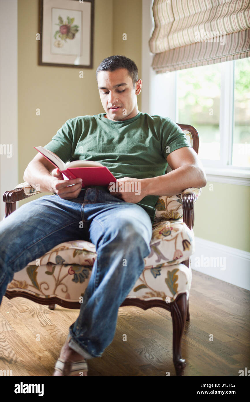 France, Paris, Young Man reading book Banque D'Images