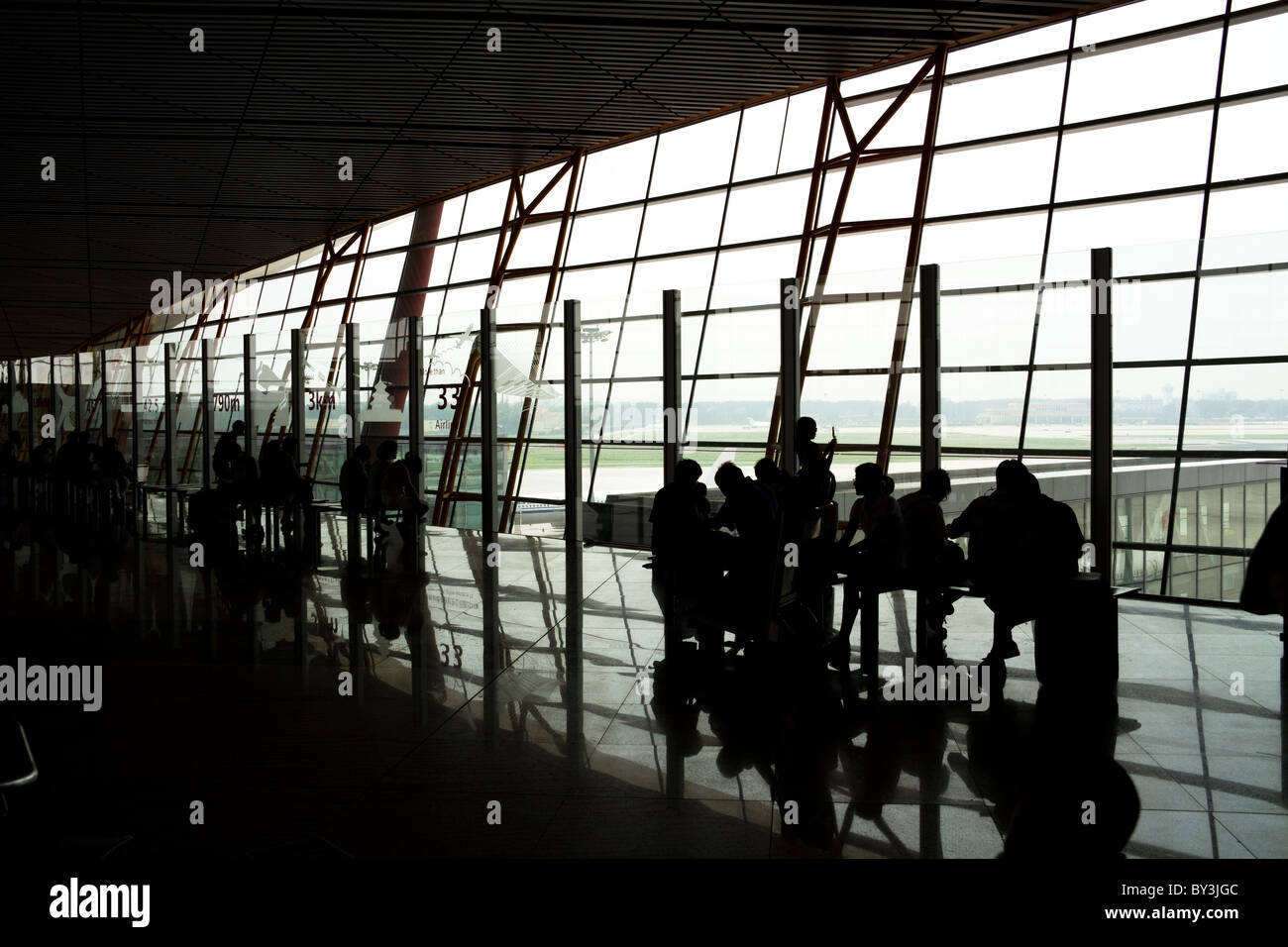 Silhouettes et réflexions d'attente des passagers à l'aéroport de Pékin Banque D'Images