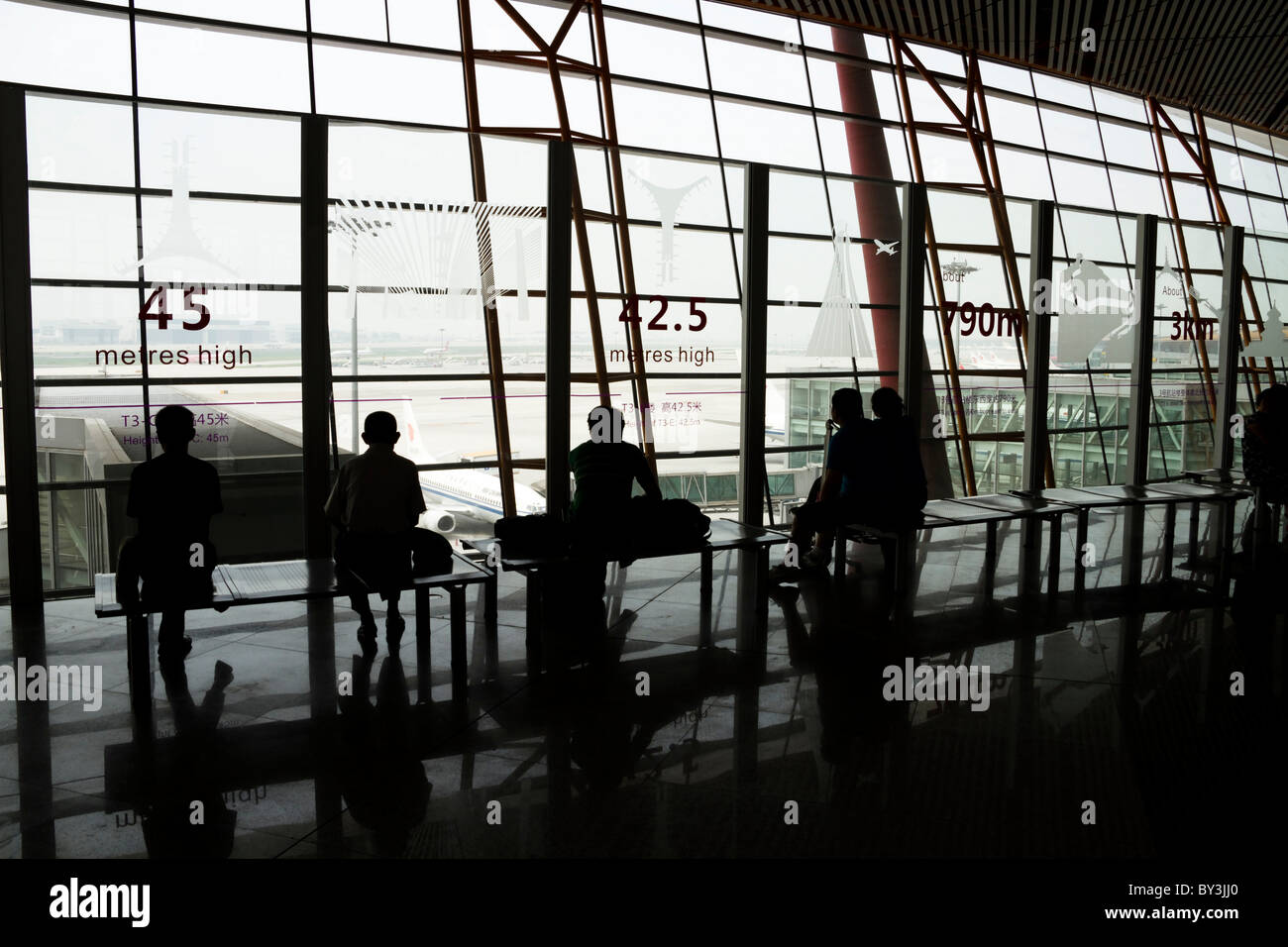 Silhouettes et réflexions d'attente des passagers à l'aéroport de Pékin Banque D'Images