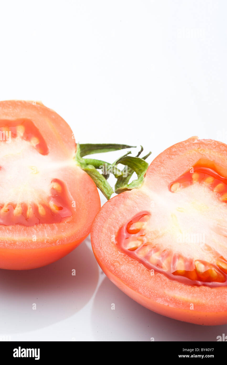 Couper la tomate sur fond blanc Banque D'Images