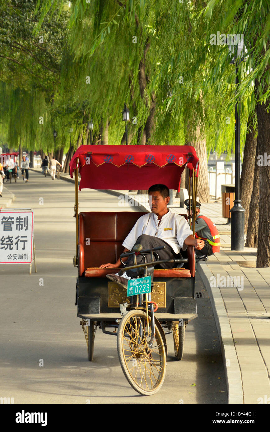 Un conducteur de pousse-pousse Chinois attendent des passagers, Beijing, Chine CN Banque D'Images