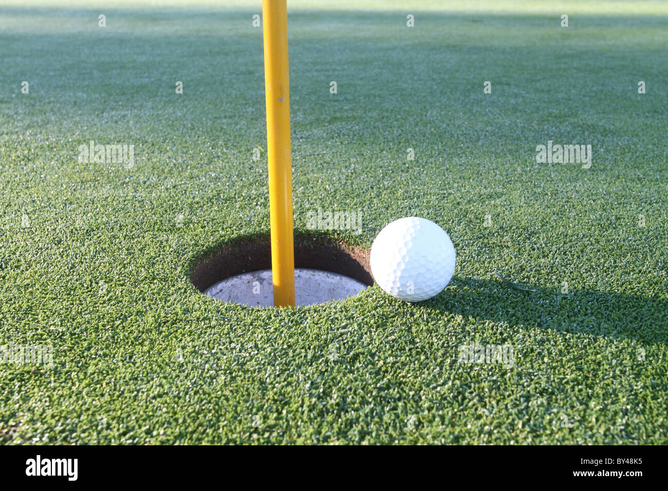 Green avec balle de golf près du trou Banque D'Images