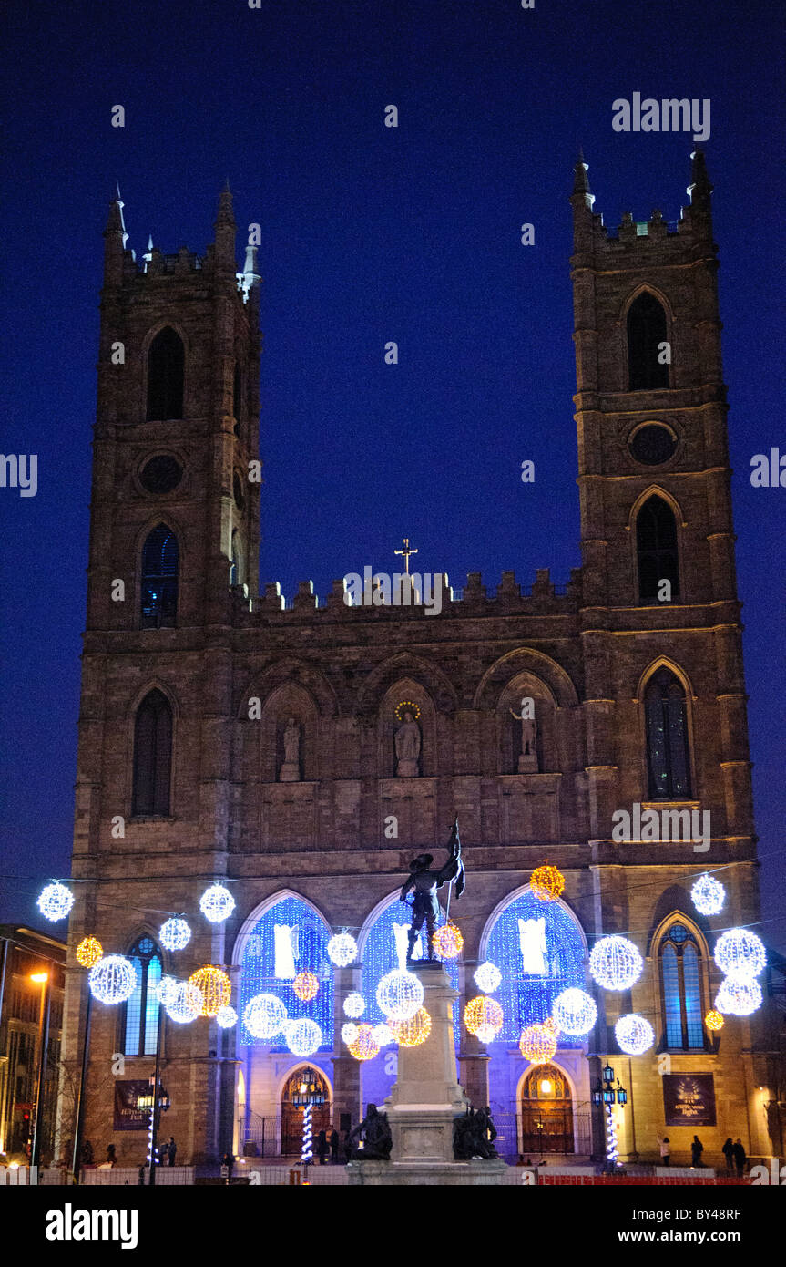 Lumières de Noël de la basilique notre-Dame Montréal Canada // MONTRÉAL, Canada — des lumières de Noël illuminent la place d'armes avant la basilique historique notre-Dame pendant la saison hivernale. La place historique, datant de la période coloniale de Montréal, constitue un avant-plan spectaculaire de la basilique néo-gothique. Cette exposition festive dans le quartier historique du Vieux-Montréal crée l'une des scènes hivernales les plus photographiées de la ville. Banque D'Images