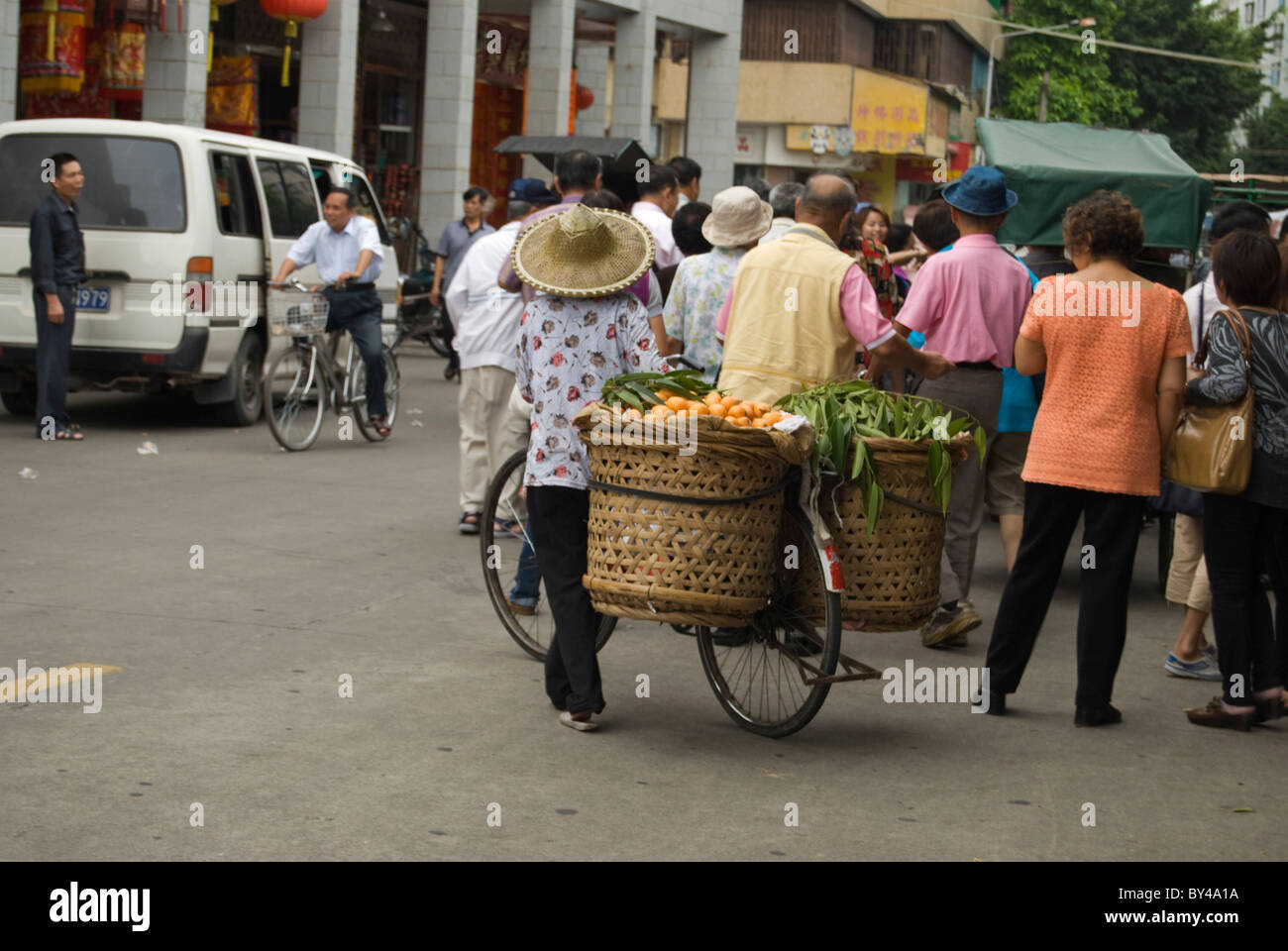 Vendeur de rue sur son vélo suit les touristes dans l'espoir de vendre ses fruits Banque D'Images