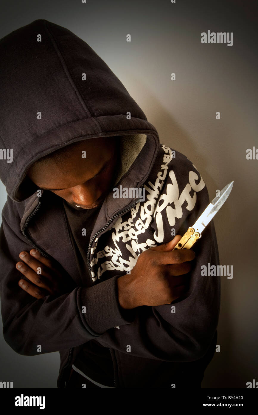 Les jeunes les jeunes noirs à capuche modèle portant une tenue un couteau Banque D'Images