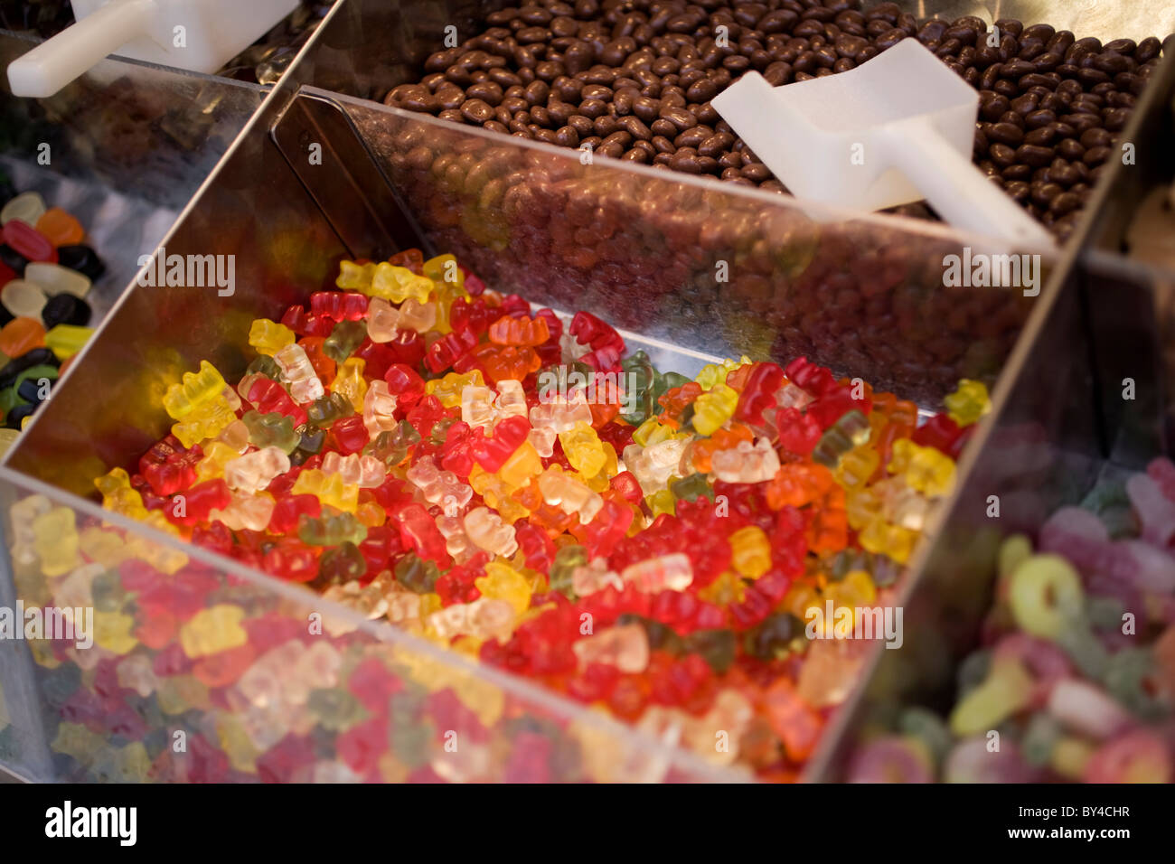 Un bac rempli de bonbons ours gummi, parmi d'autres bacs de bonbons Banque D'Images