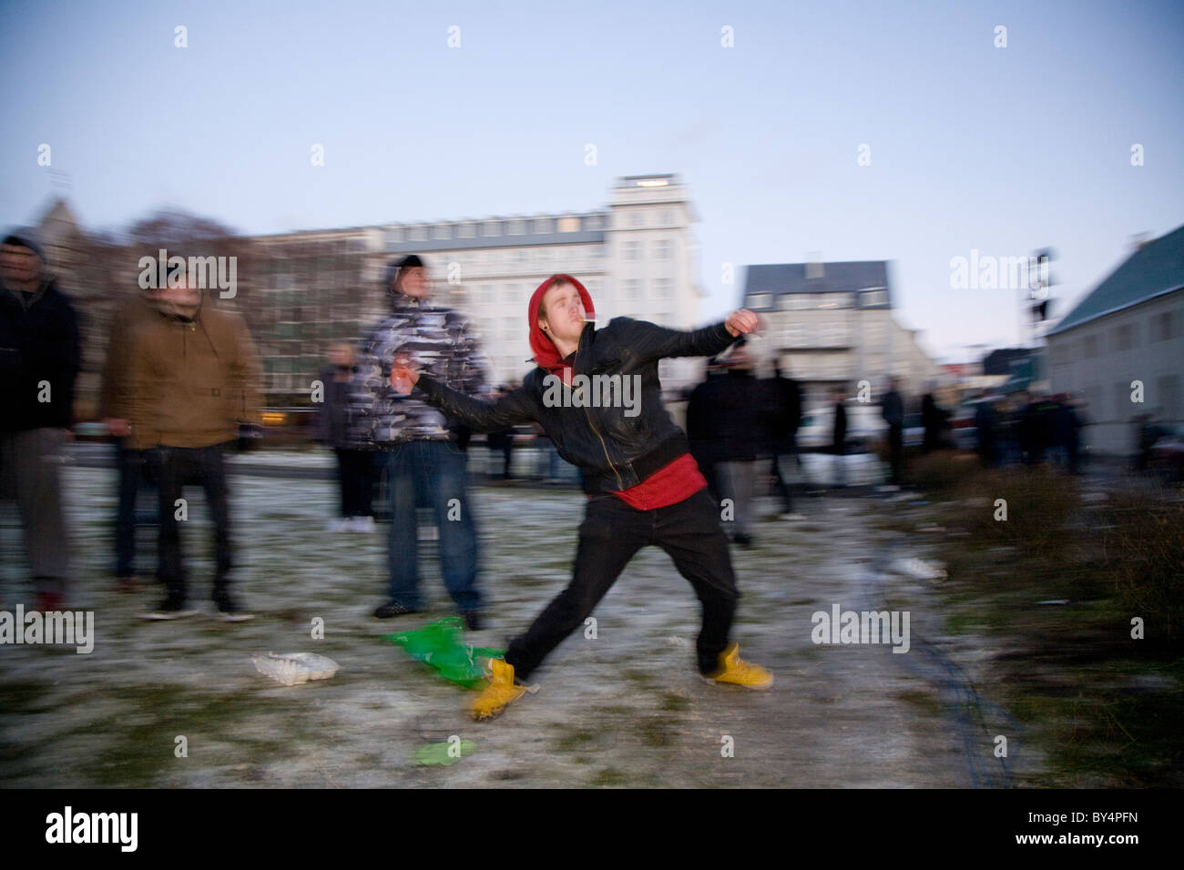 Le centre-ville de Reykjavík, Islande : manifestants protester devant le Parlement islandais. Jeune homme jette des tomates à l'Parli Banque D'Images