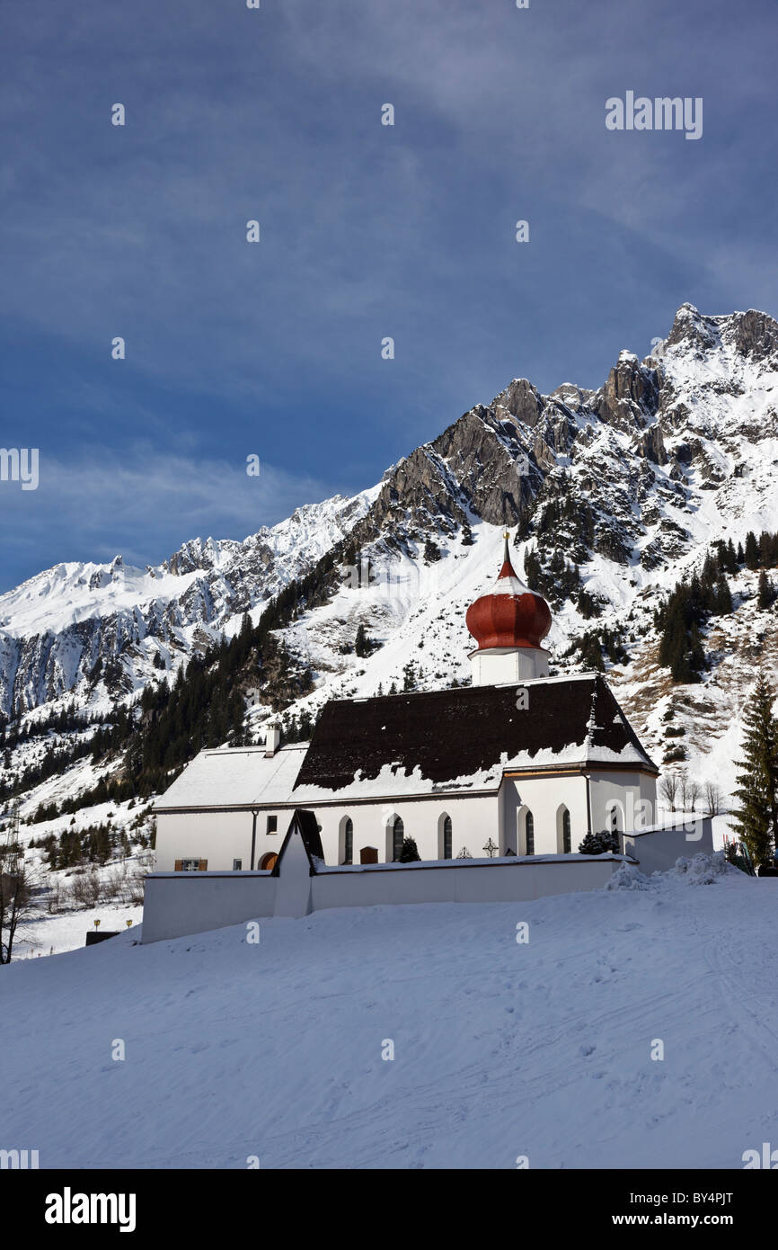 L'église de Stuben dans l'Alberg ski area sur fond de montagnes couvertes de neige. Banque D'Images