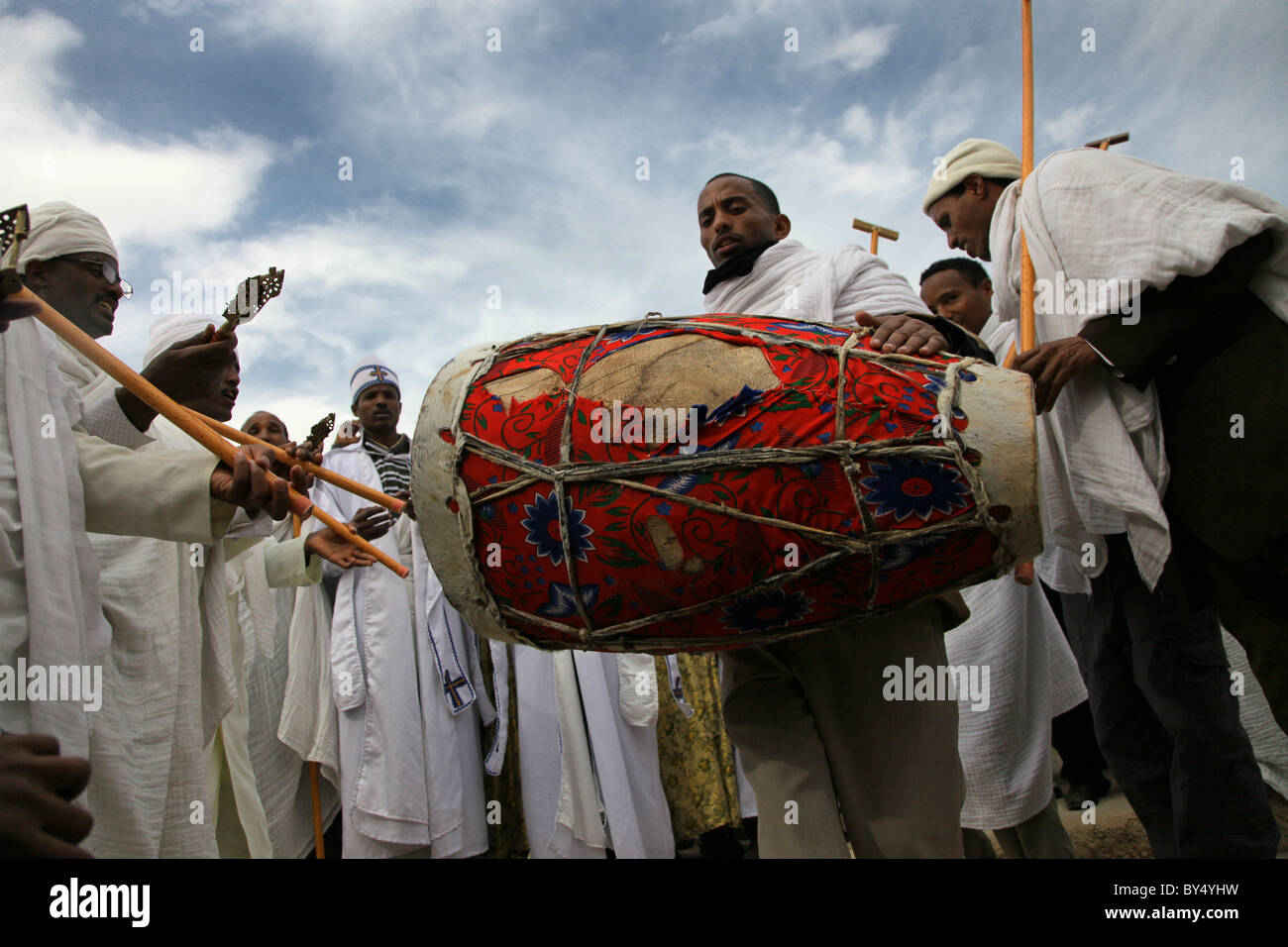 Fidèles orthodoxe éthiopienne le Kebero jouant un double-dirigé, conique tambour à main utilisés dans la musique traditionnelle de l'Érythrée et l'Éthiopie Banque D'Images