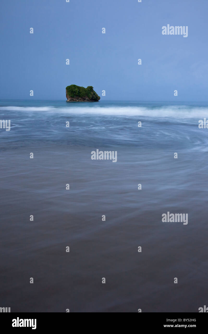 La mer des Caraïbes en face de Cocles Rock au crépuscule le long de la plage de Playa Cocles, province de Limón, Costa Rica. Banque D'Images