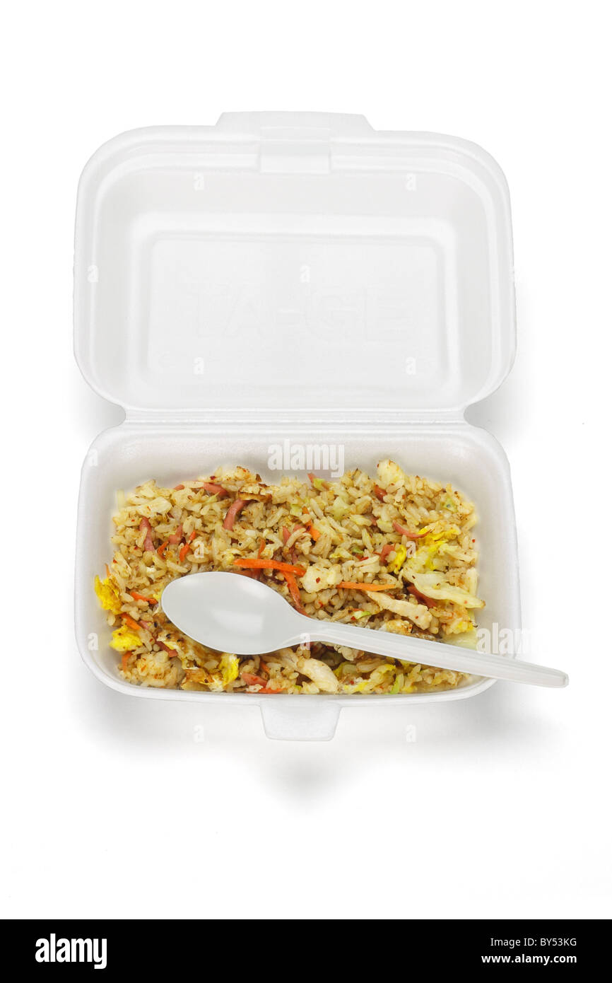 Riz frit dans boîte en polystyrène avec cuillère jetable en plastique sur fond blanc Banque D'Images