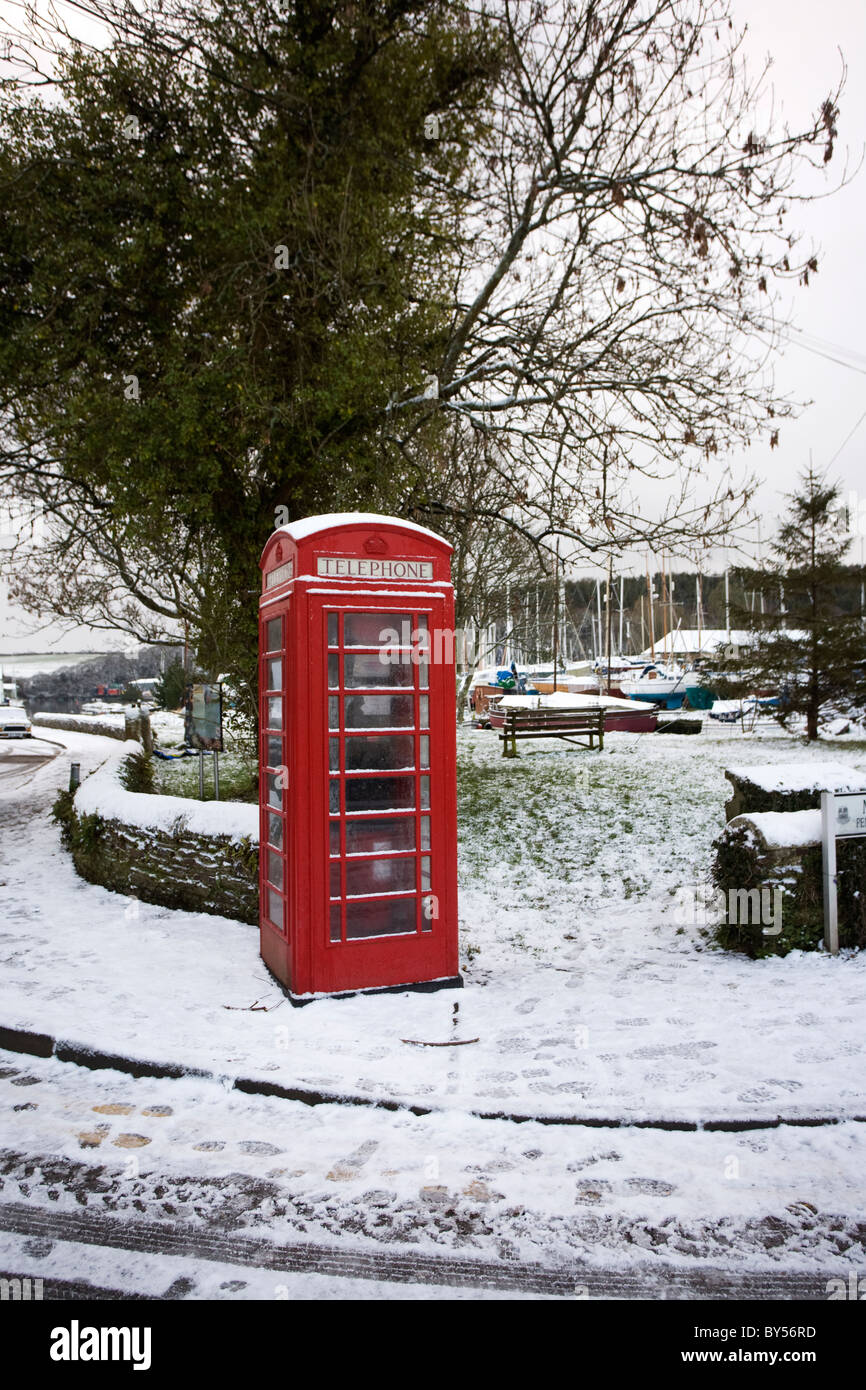 Une cabine téléphonique rouge dans la neige à Gweek, Cornwall Banque D'Images