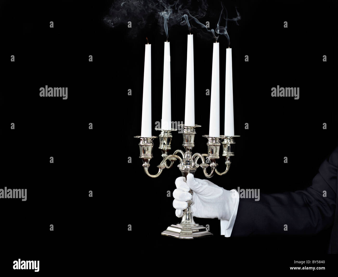 Un homme tenant un candélabre avec bougies éteintes Banque D'Images