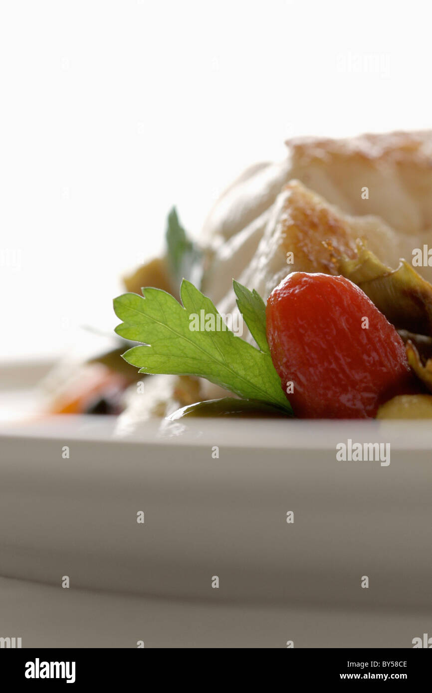 La lotte avec une garniture de tomate et la coriandre, extreme close up Banque D'Images