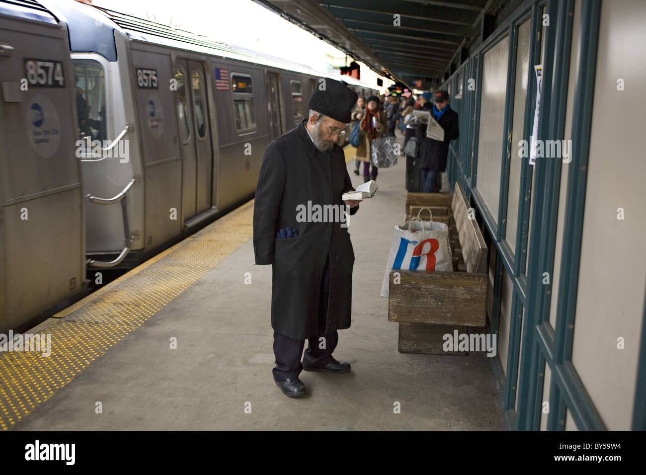 L'homme Juif orthodoxe prières dit sur la plate-forme du métro lorsque le train entre dans la gare de Williamsburg, Brooklyn, NYC Banque D'Images