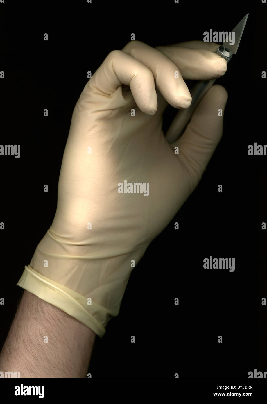 Un homme portant un gant de chirurgie et la tenue d'un scalpel, directement au-dessous, la main seulement Banque D'Images