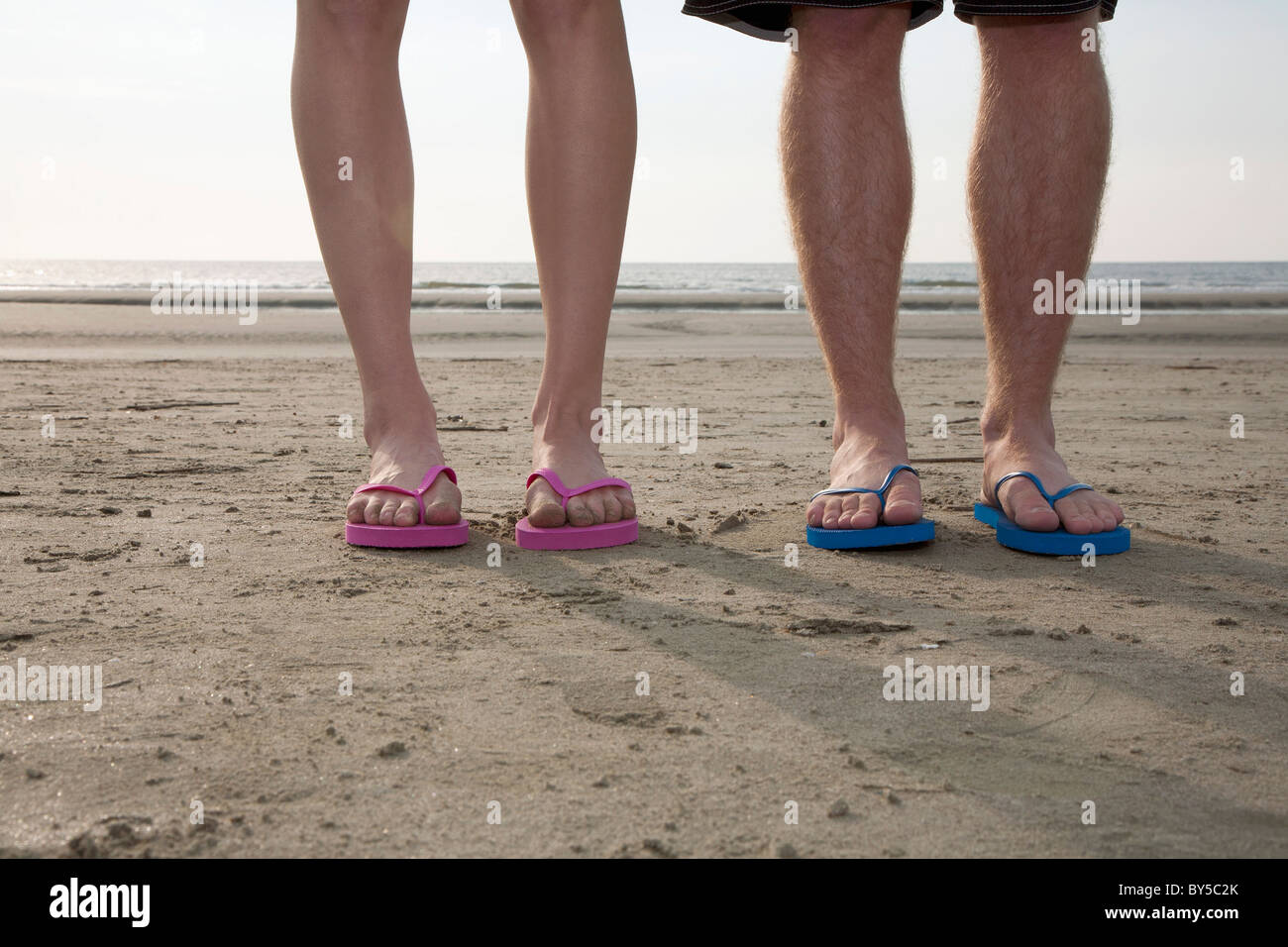 Un jeune couple de porter des tongs à la plage, low section Photo Stock -  Alamy
