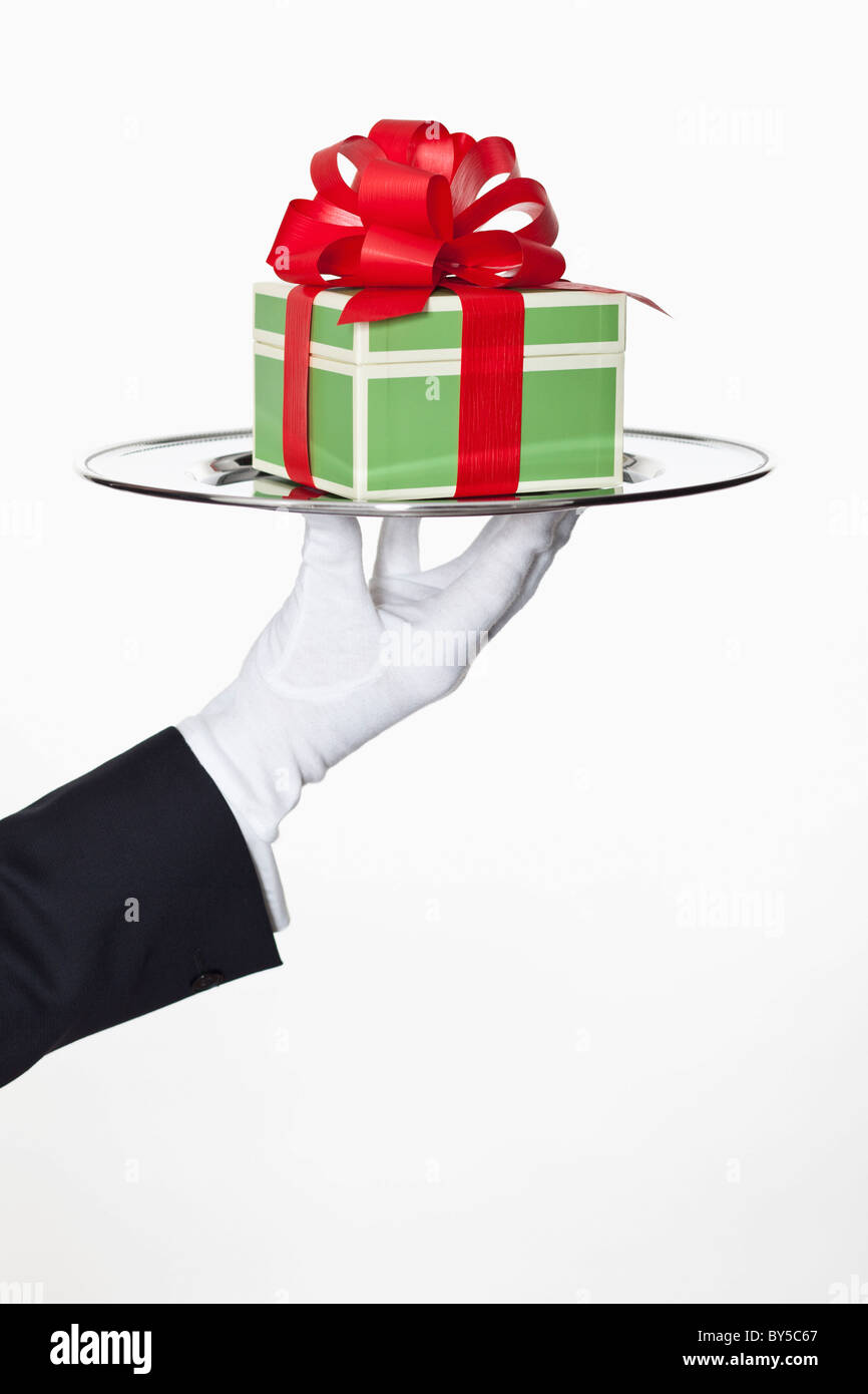 Un majordome présentant un cadeau sur un plateau d'argent, focus on hand Banque D'Images
