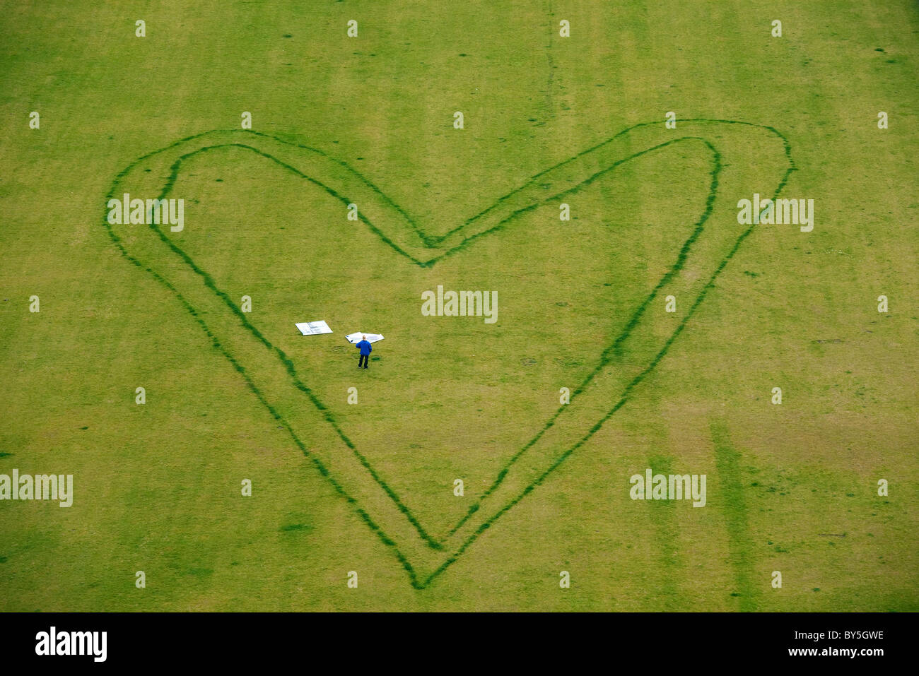 Allemagne, Berlin, coeur géant design sur pelouse avec une personne se tenant debout à l'intérieur Banque D'Images