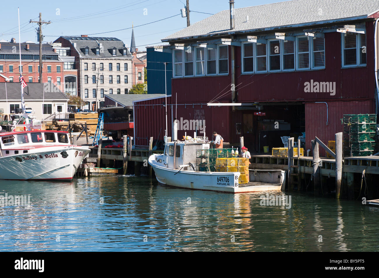 Les appâts des pêcheurs des casiers à homard et les charge sur le bateau de pêche commerciale au homard au quai à Portland, Maine Banque D'Images