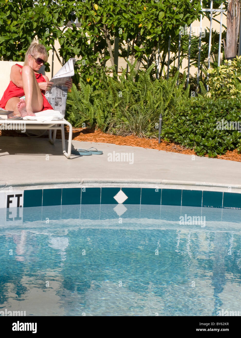 Femme en vacances en Floride, à côté d'une lecture extérieure Banque D'Images