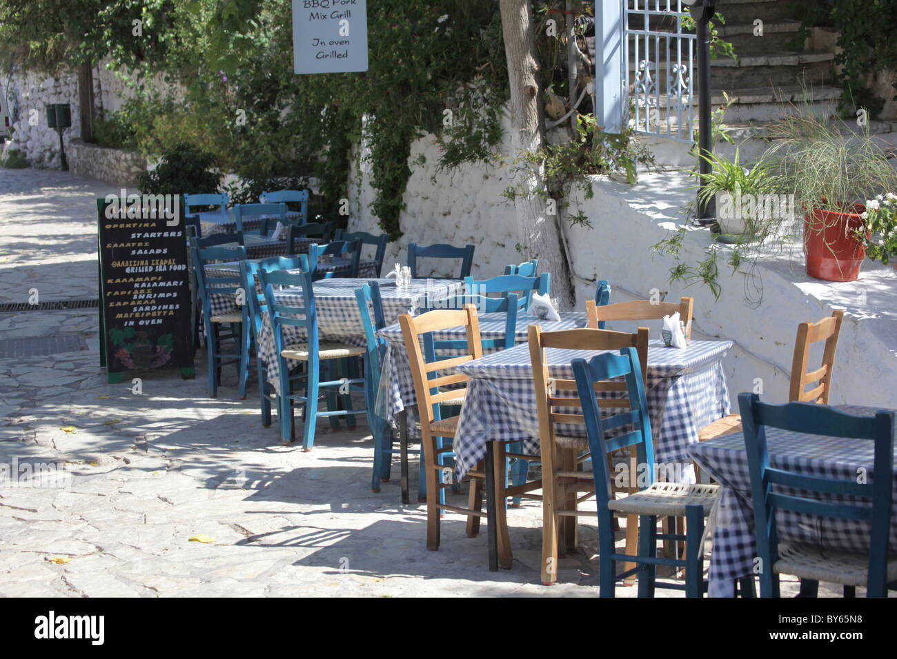Restaurant rue Agios Nikitas dans avec des tables sur le trottoir - Athènes, Grèce Banque D'Images
