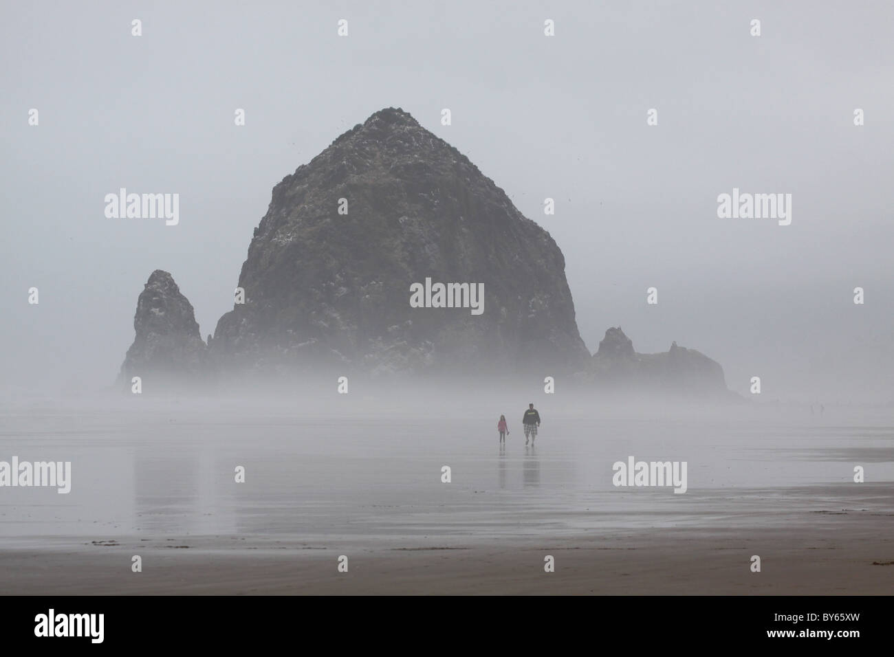 Les randonneurs plage Haystack Rock Cannon Beach Oregon Coast le brouillard Banque D'Images