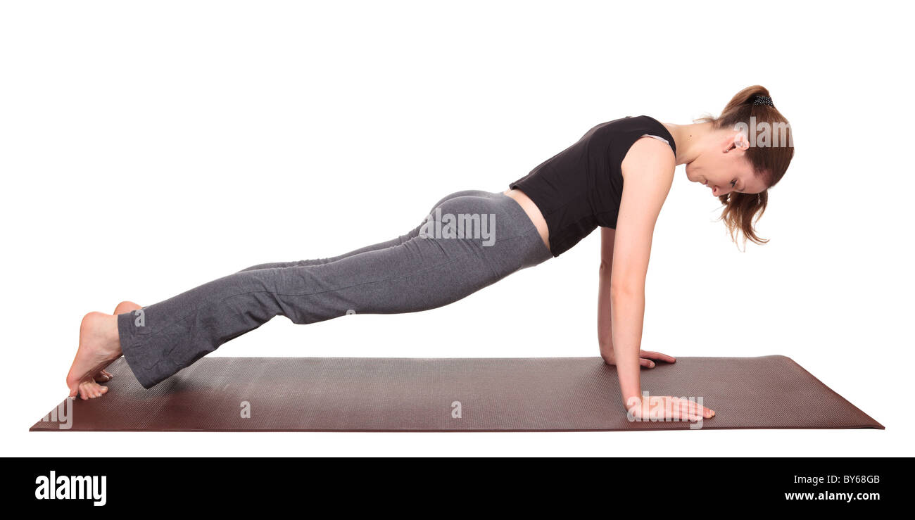 Studio isolé d'un coup monter Caucasian woman holding la planche yoga position sur un tapis d'exercice. Banque D'Images