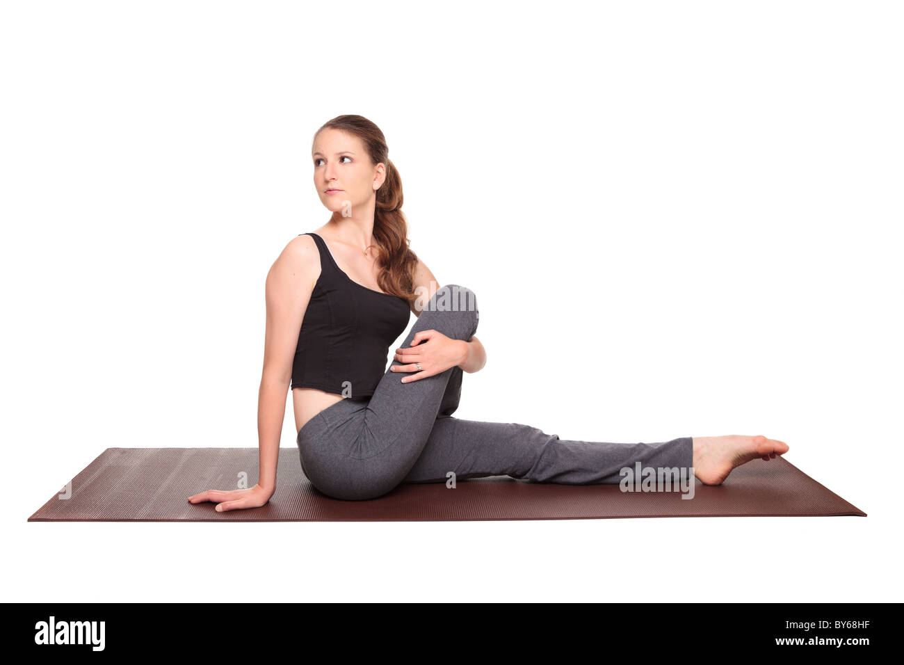 Studio isolé d'un coup monter Caucasian woman holding l'ardha matsyendrasana demi torsion spirale assis sur une position de yoga exer Banque D'Images