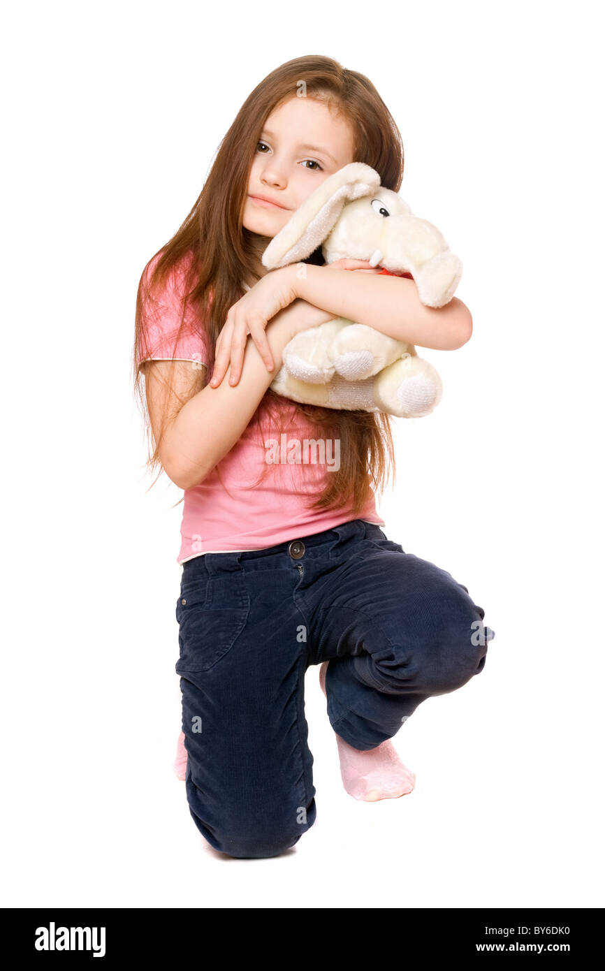 Happy little girl avec un ours en peluche éléphant. Isolé Banque D'Images