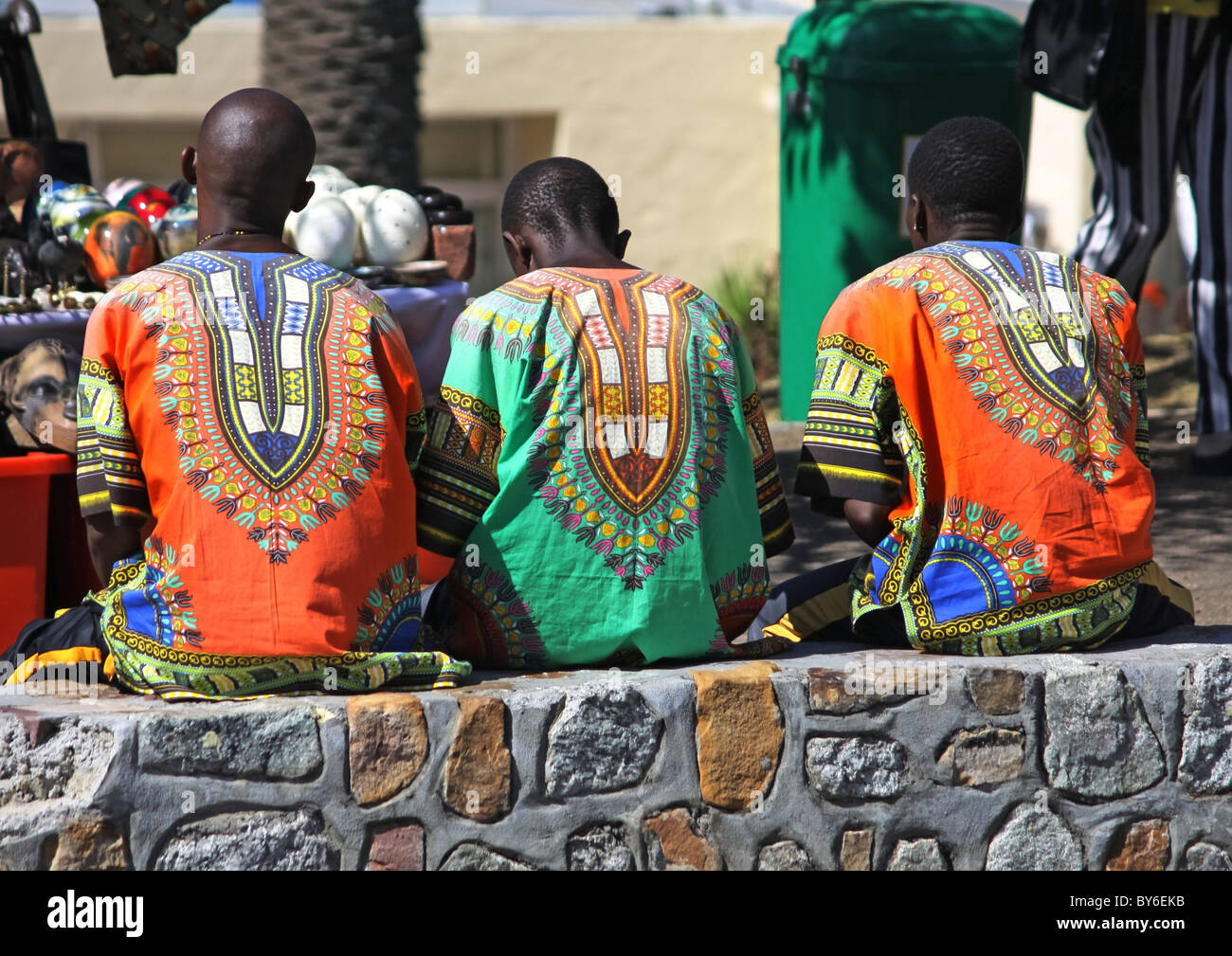 Les vendeurs de rue sud-africains en costume traditionnel sitting on wall Banque D'Images