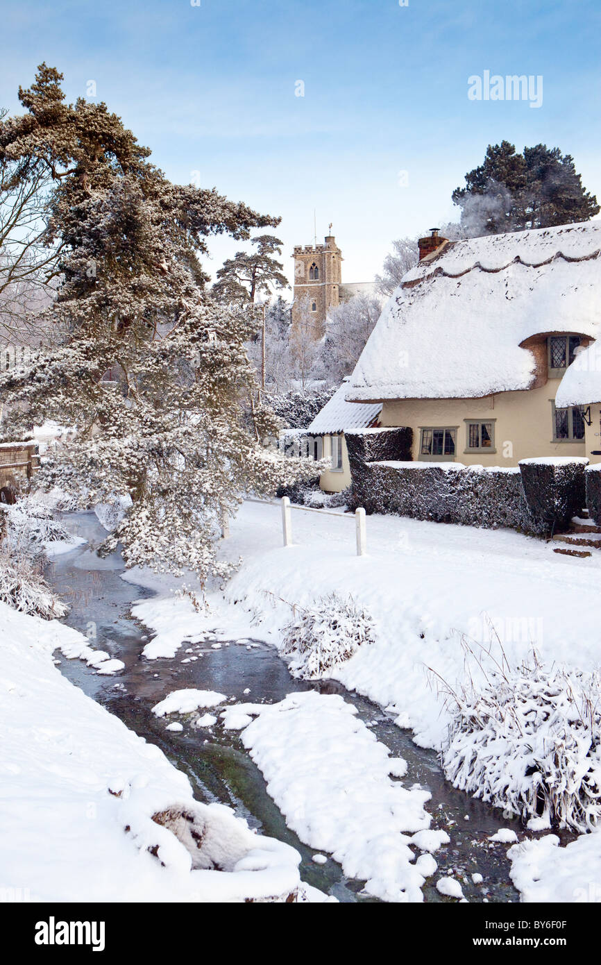 Scène de la neige d'hiver de la Essex village de Arkesden avec ses pittoresques chaumières et église Banque D'Images