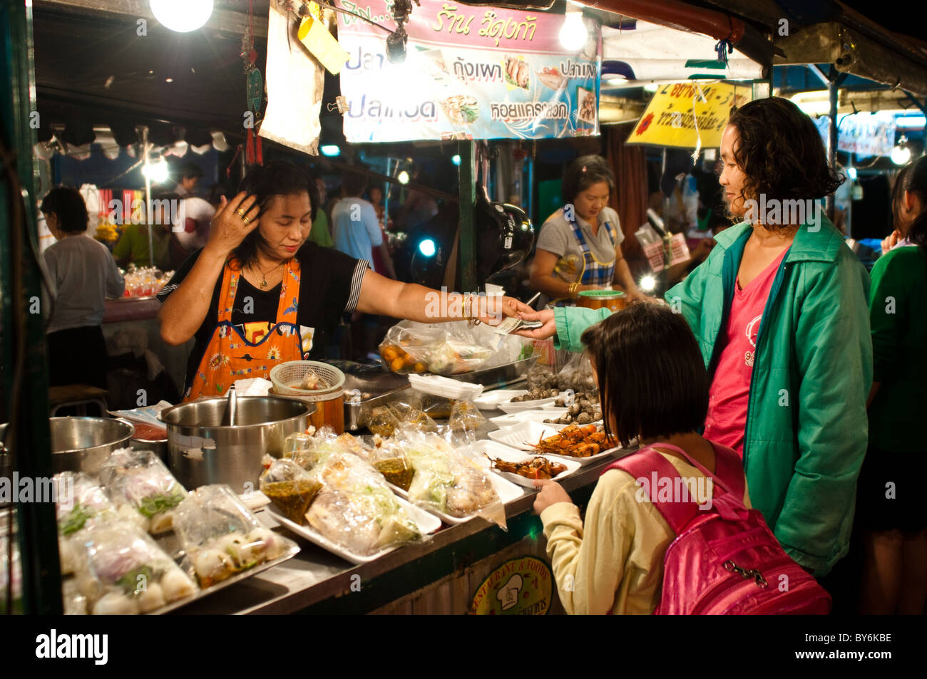 Mère et fille l'achat d'un plat, marché alimentaire nocturne, Phitsanulok, Thaïlande Banque D'Images