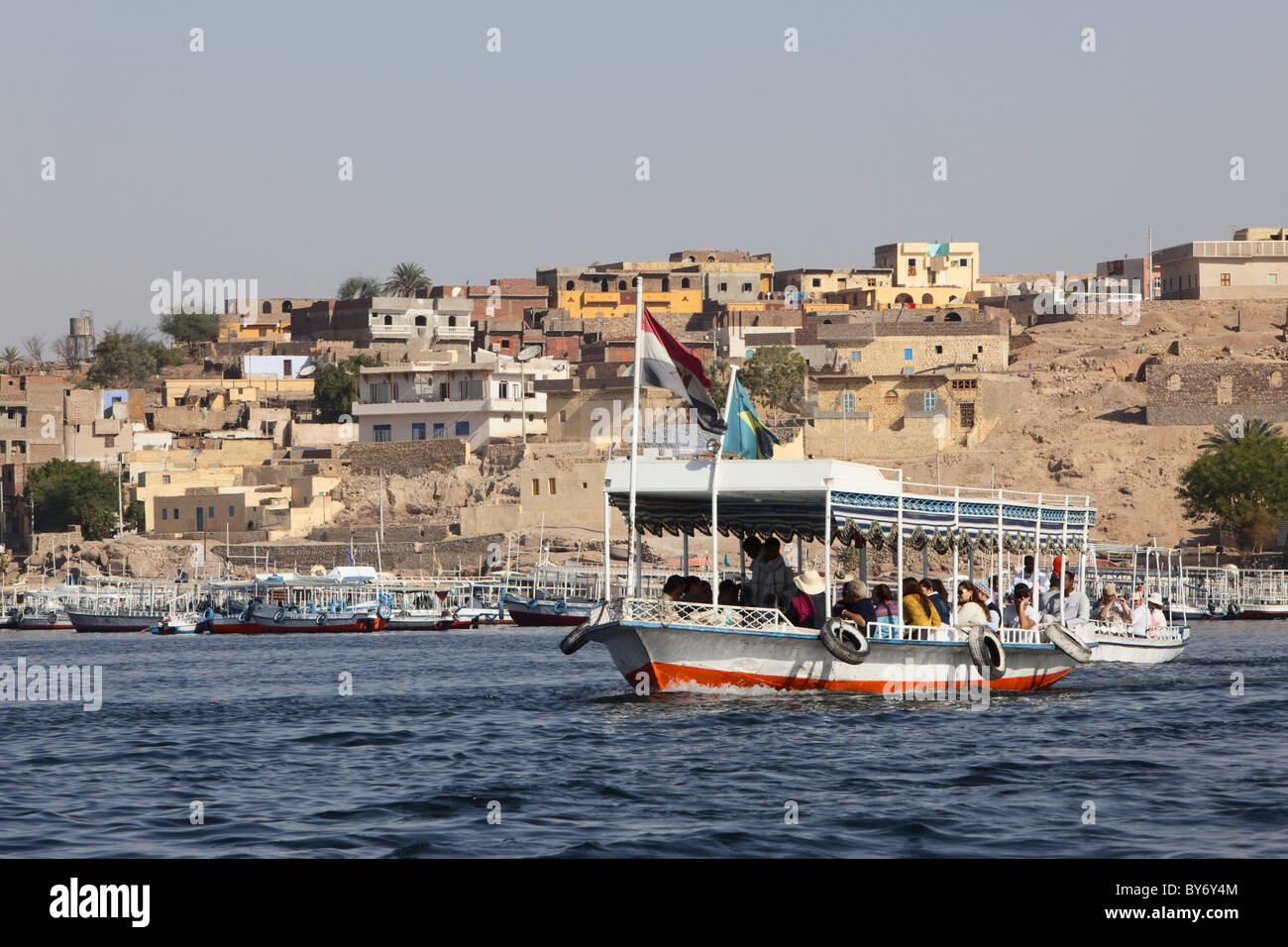 Bateau de tourisme sur son chemin vers le temple de Philae, un règlement de Nubie dans l'arrière-plan, Assouan, Egypte, Afrique du Sud Banque D'Images