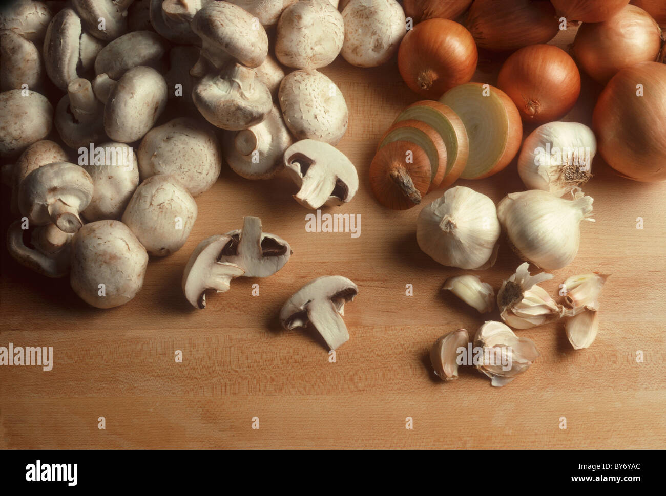 Les champignons, les oignons et l'ail sur une surface en bois butcherblock Banque D'Images