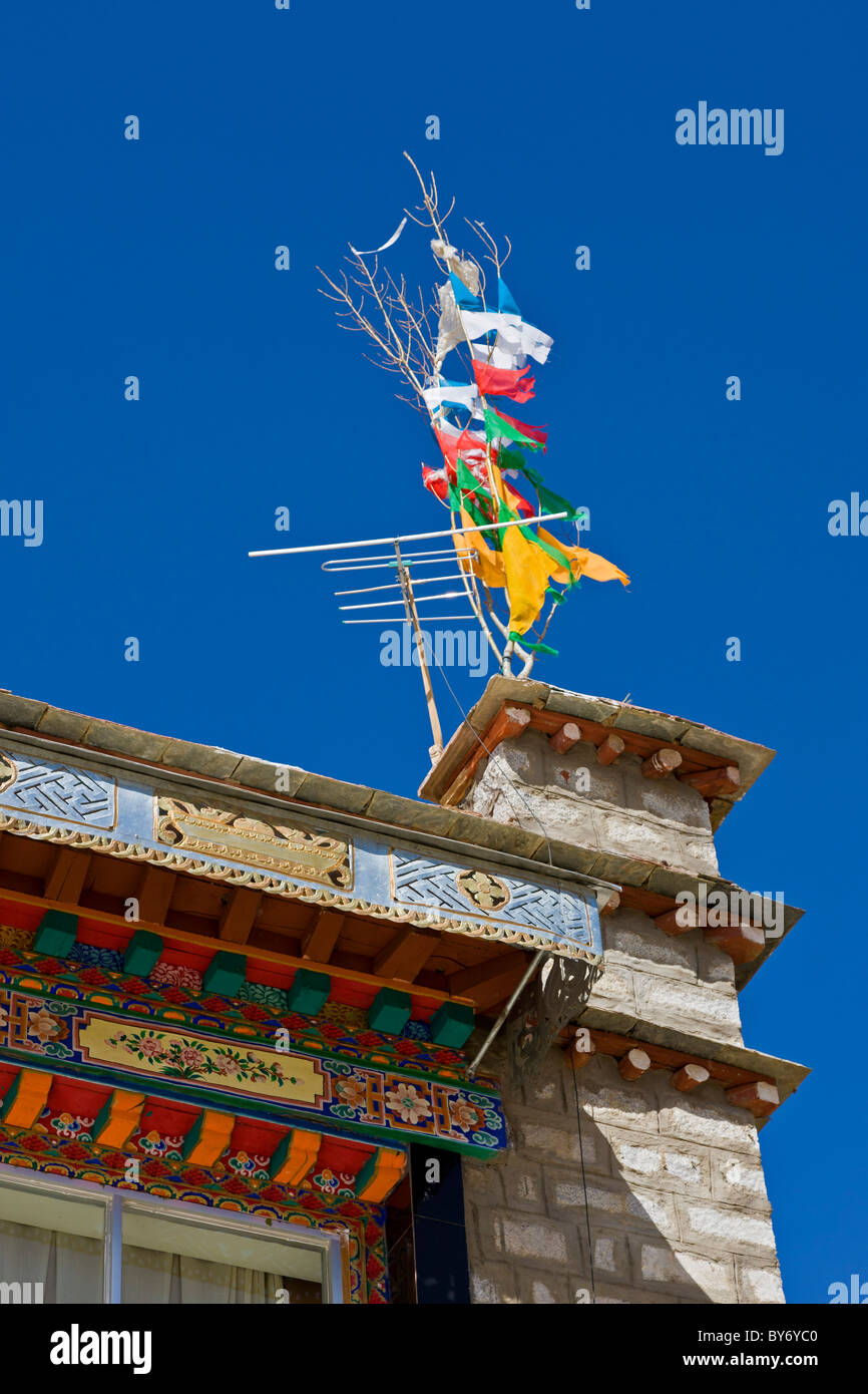 Drapeaux traditionnels et de télévision antenne sur toit de maison dans village tibétain sur la route de l'aéroport de Lhassa à Lhassa au Tibet. JMH4418 Banque D'Images