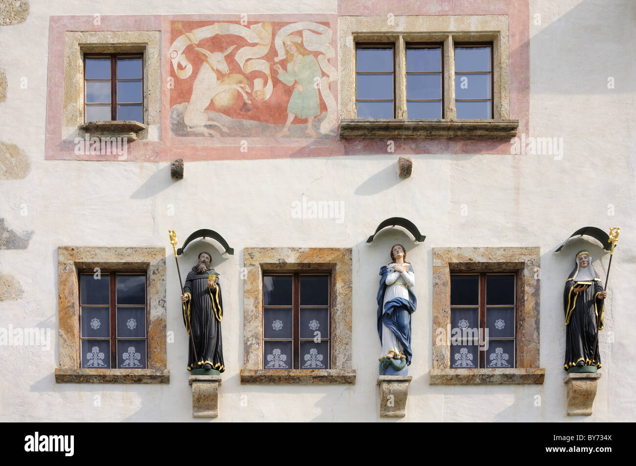 Façade de maison avec windows, les figures de saints et fresque murale, cloître, Muestair Muestair, Site du patrimoine mondial de l'Muestair, Banque D'Images